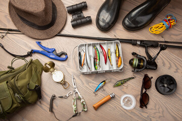Fishing rod, tackles and other stuff for recreation activity on the wooden desk. Fishing season...
