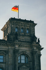 Fototapeta na wymiar view of huge tower side of german majestic architectural building on sunny morning with huge flag on top 