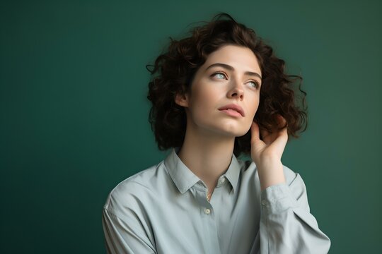 Gedankenverlorenes Portr&auml;t vor Gr&uuml;nem Hintergrund, Frau mit Haaren
