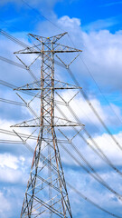 Transmission line pylon lattice tower, blue sky with clouds background