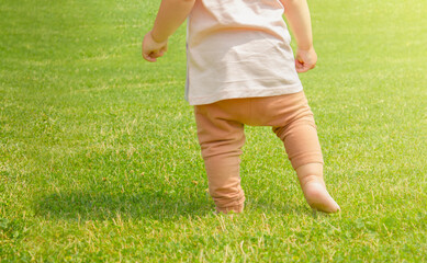 A one-year-old child is learning to walk