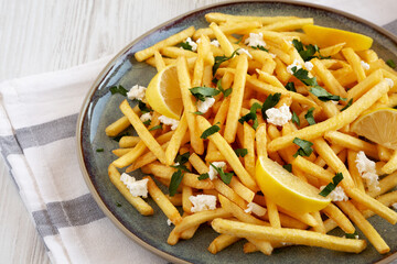 Homemade Greek Fries with Feta and Tzatziki on a Plate, side view. Copy space.