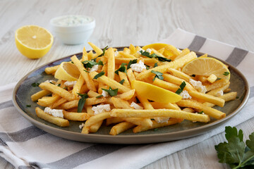 Homemade Greek Fries with Feta and Tzatziki on a Plate, side view.