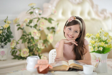 Close up portrait of young girl reading interesting big book