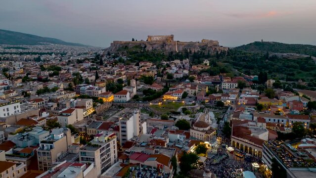 Aerial time lapse view of the illuminated old town of Athens Plaka with Monastiraki square and the Acropolis during sunset and dusk