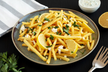 Homemade Greek Fries with Feta and Tzatziki on a Plate, side view.