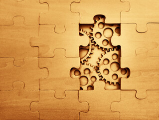 solving the problem concept - puzzles and cogwheels. wooden gears under the puzzle, the concept of...