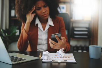 Frustrated young businesswoman working on a laptop computer sitting at his working place