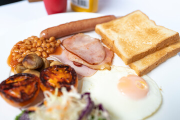 English breakfast with hame, sausage and fried egg on white background.