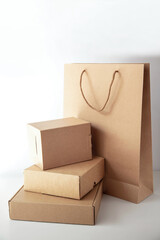 Cardboard boxes of different shapes and paper bag are placed on a light background. The theme is recycled product. Vertical picture.