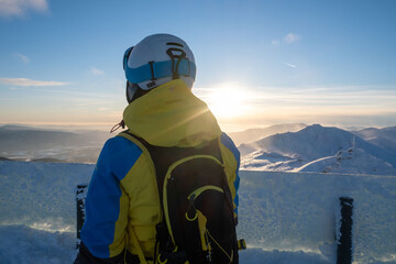 woman skier looking at sunset above slovakia mountains