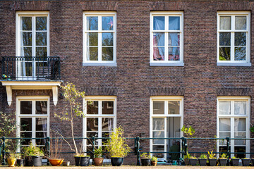 Typical canal houses with the famous Amsterdam posts along the sidewalk.