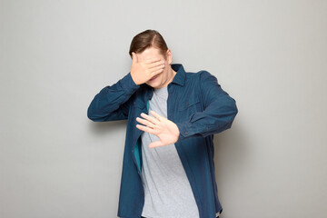 Shot of mature man is covering his face with hand protecting himself