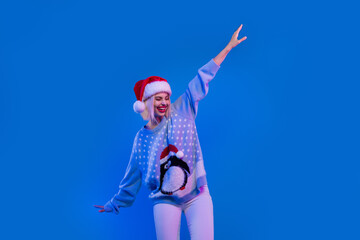 Fototapeta na wymiar Photo of pretty adorable woman santa elf wear ugly print x-mas pullover dancing isolated blue color background