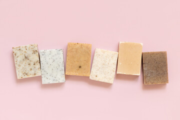 Beige and brown handmade soap bars on light pink top view. Natural herbal product for SPA