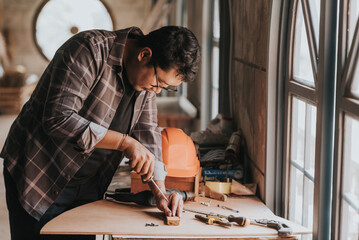 a Young man Carpenter works on woodworking machinery in a carpentry shop. The workshop looks professional, highly skilled, and the craftsmen are true craftsmen.