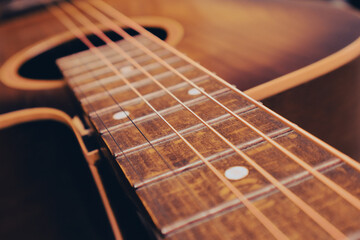Photo of a old wooden guitar with steel strings. Close up of a acoustic guitar string and fingerboard with strings. Music concept.