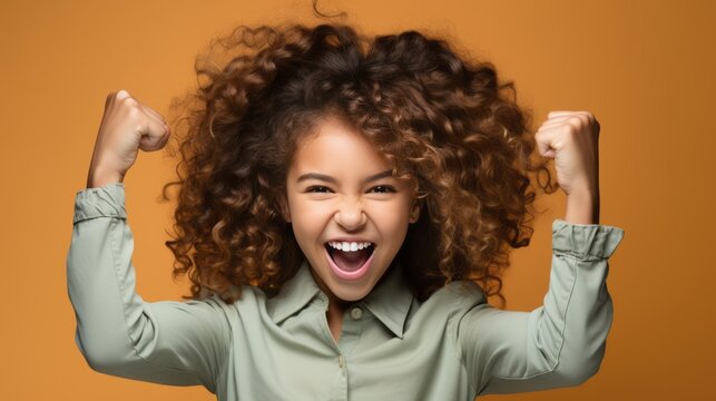 Curly-haired teenager with raised arms, singing and shouting in excitement.