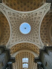 ceiling with three pillars and a circular sky light above it