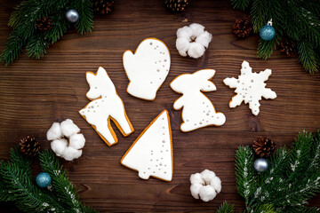 Obraz na płótnie Canvas Homemade baked white Christmas cookies with fir tree branches. New Year background