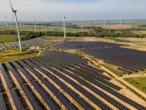 Aerial view of soalr panels  situated in a vast grassy field in Taurage, Lithuania