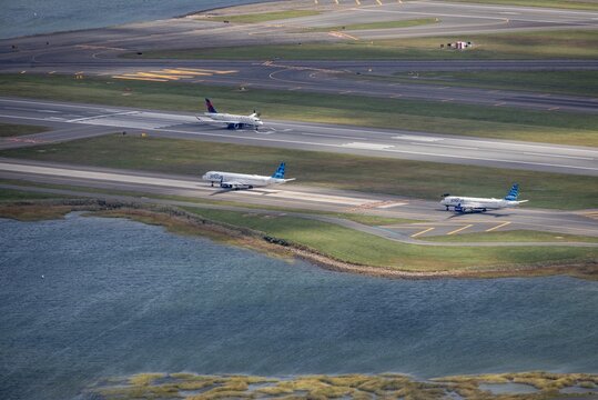 An aerial photograph of a Delta Airlines planes at an airport in Boston