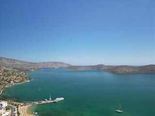 Obraz premium Aerial view of Elounda Bay on the Greek island of Crete with a boat sailing along the shore