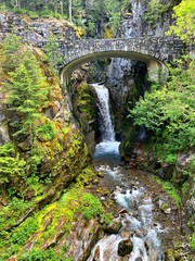 Fototapeta na wymiar Majestic waterfall cascading underneath a bridge in Crater Lake National Park, Oregon, USA