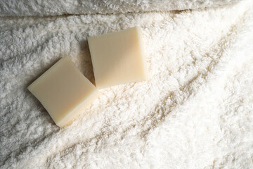two bars of soap lie on a towel