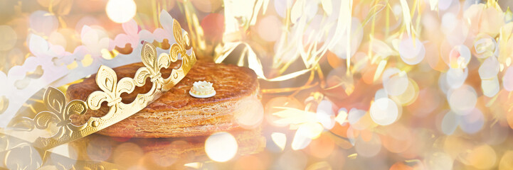 Galette des rois, french kingcake with a  crown, panoramic holiday bokeh lights web banner
