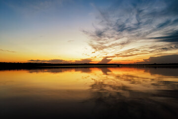 Fototapeta na wymiar Vibrant sky reflecting on a calm and serene lake