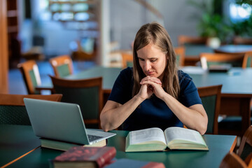 A visually impaired woman sitting and studying in the university library