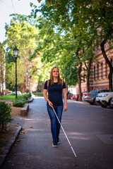 Portrait of a blind woman with white cane walking on the street