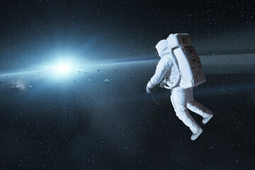 Cosmonaut in deep space with sun light. Elements of this image furnished by NASA.