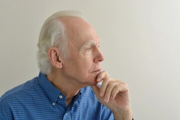 Portrait of an elderly serious thoughtful gray-haired man looking into the distance