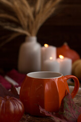 Autumn festive decor on the table with a cup of hot drink, still life. Romantic candlelit evening, Autumn festival and Halloween