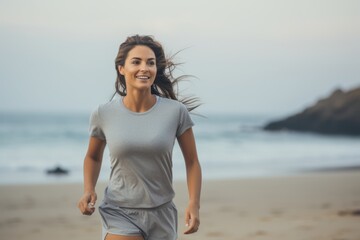 Fototapeta premium Medium shot portrait photography of a satisfied girl in her 30s jogging on the beach. With generative AI technology