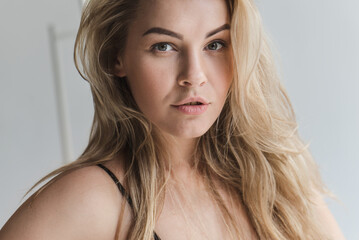 Naklejka premium emotional close-up portrait of a blonde woman with gorgeous hair. Sexy blonde smiles and enjoys life