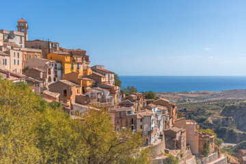 Fototapeta premium The hillside town of Badalato Italy with homes perched on the side of a hill overlooking the ocean