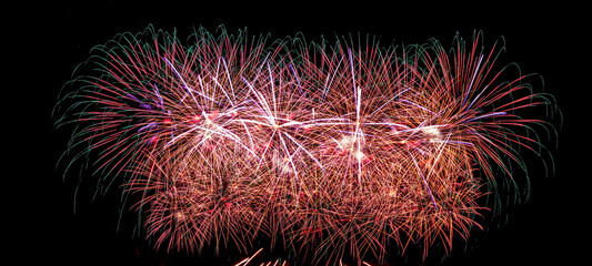 Colorful celebration fireworks isolated on a black sky background.