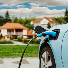 Electric car is charged in suburb - 660467304