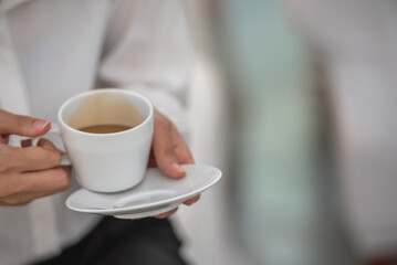 Banner of Asian woman Proprietor holding hot coffee in white ceramic cup to sniff smell of espresso in office work place . business owner entrepreneur girl carry coffee break to sniff fragrant smell