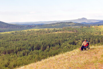 Fototapeta na wymiar beautiful mature couple on the slope of the mountain of the southern Urals on a summer day