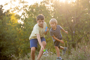 Fototapeta premium Sweet children, boys, playing in the park on sunset, autumn