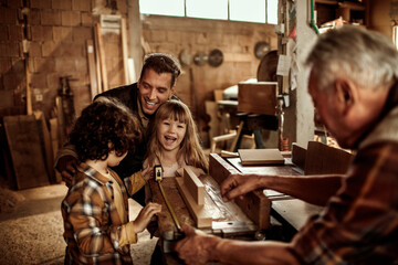 Young future carpenters learning the ways of their elders in a wood shop