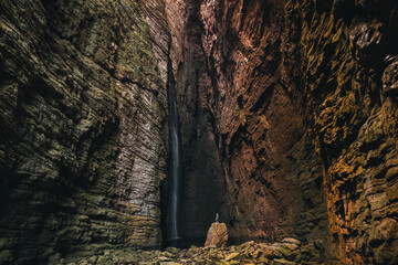 
man on top of a rock admiring Cachoeira da Fumacinha, Vale do Pati, Chapada Diamantina, Bahia, Brazil
