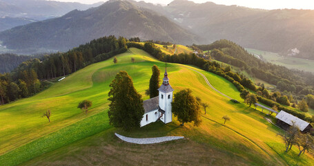 Aerial view of St. Thomas church on top of a hill, sunrise, Skofja Loka, Slovenia