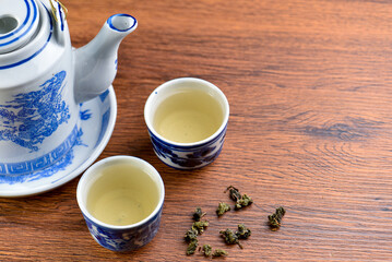 White Ceramic Chinese style Teapot pouring Chinese tea in Ceramic cup. White Ceramic Chinese style Teapot set for tea break time.