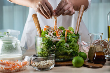 Hand chef mix fresh baby cos salad millet Crab Stick and pour salad dressing in wood blow. Organic Vegetables mix lunch with green salad In bowl. Breakfast fresh salad and clean vegetable