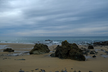 View on a sandy coast of bay of Biscay with large rocks